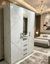 Modern bedroom with a large mirror wardrobe and a bed in the background.